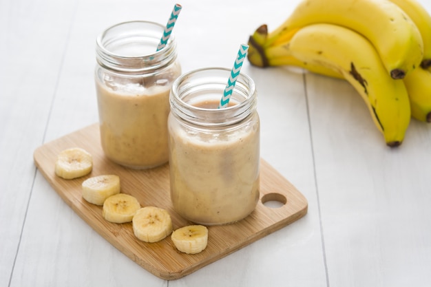 Banana smoothies in jar on white wooden table