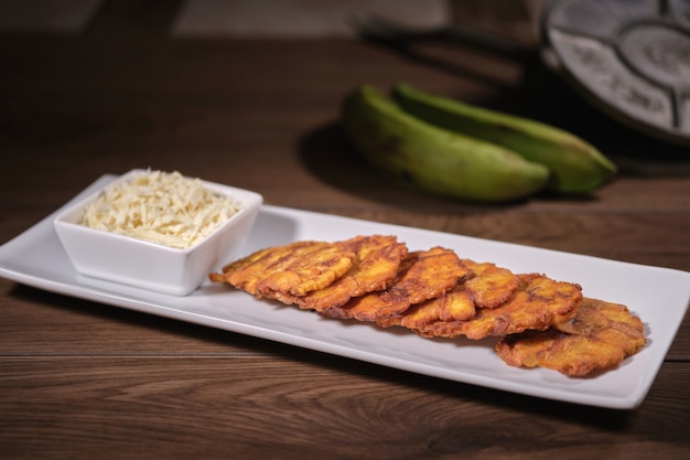 Foto tostones alla banana con formaggio con cibo venezuelano in legno