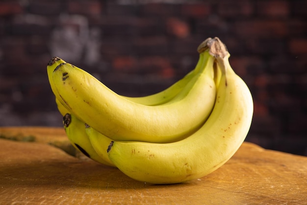 Bananas, beautiful bunch of bananas arranged over rustic wood, selective focus.