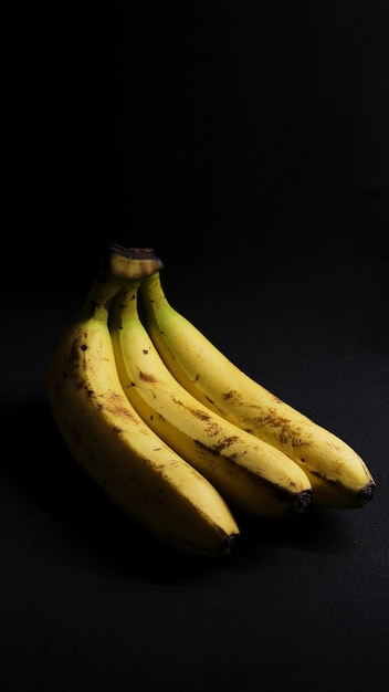 Photo bananas on black background. darkfood