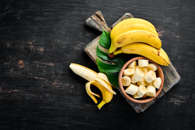 Banane su una superficie di legno nera frutti tropicali vista dall'alto spazio di copia gratuito