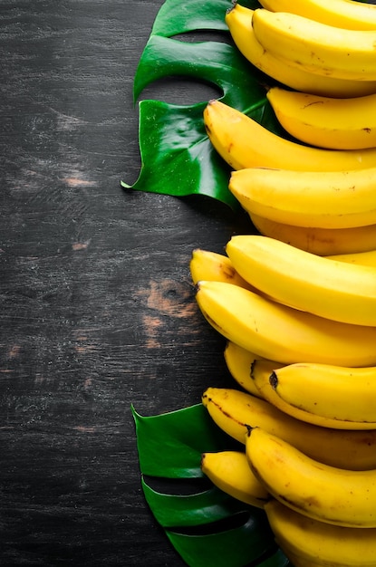 Bananas on a black wooden surface Tropical Fruits Top view Free copy space