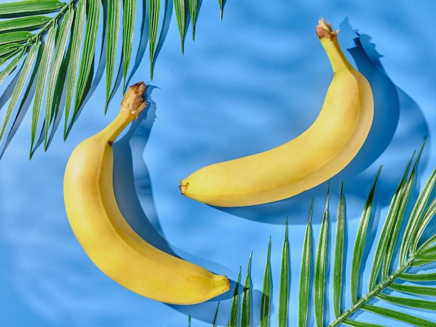 Bananas on a blue table and palm leaves