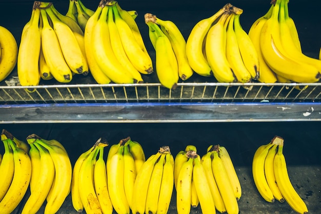 Bananas branch on shelf of store. shopping concept