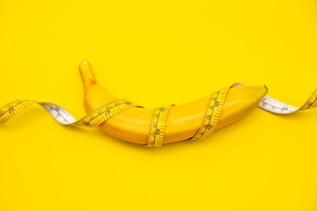 bananas have tape. on a yellow background -concept diet.