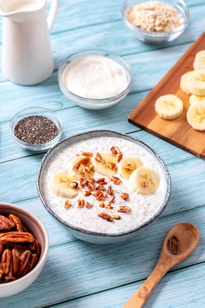 Foto bananen en pecannoten overnacht havermeel met chia zaden in een kom rijk aan eiwitten ontbijt of snack