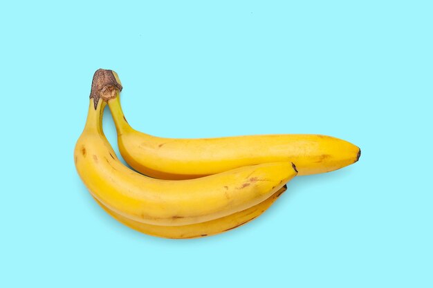 Bananen geïsoleerd op een blauwe achtergrond Drie rijpe gele bananen