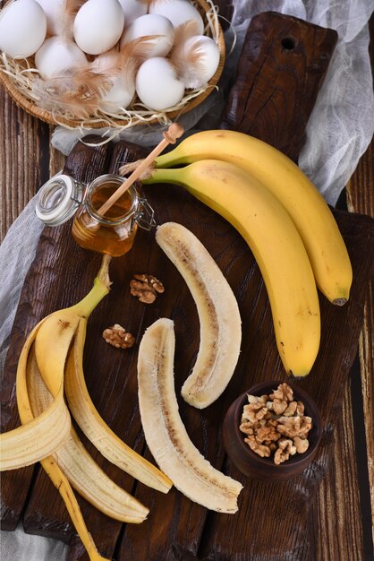 Foto bananen, noten, eieren, honing - ingrediënten voor het bakken van zelfgemaakt bananenbrood