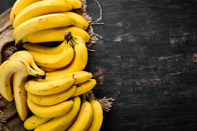 Bananen op een zwarte houten ondergrond Tropisch fruit Bovenaanzicht Gratis kopieerruimte