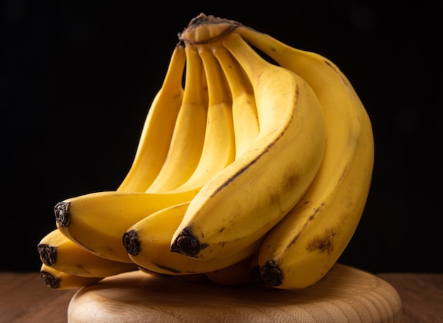 Bananen, tros bananen op een ronde houten ondergrond