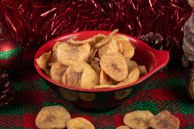 Bananenchips in een kom op een achtergrond van Kerstmis