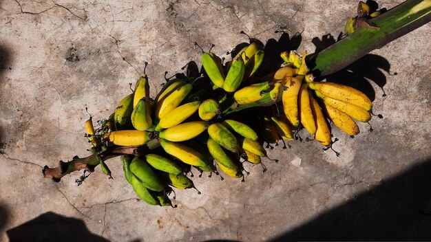 Bananenfruit met bos rijpe gele bananen, cementmuurachtergrond 02