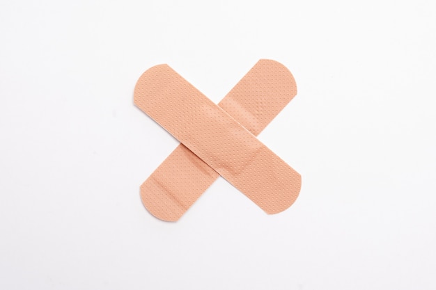 Photo band-aids forming an x or a cross on white