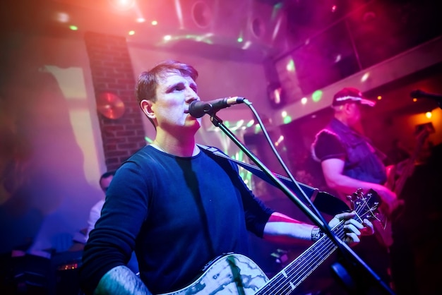 Band performs on stage, rock music concert. Warning - authentic shooting with high iso in challenging lighting conditions. A little bit grain and blurred motion effects.