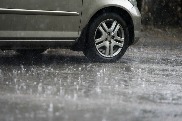 Banden met een auto die loopt terwijl het regent