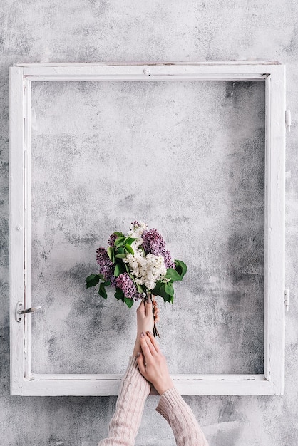 Baner girl's hand with a bouquet of lilacs in the frame copy space design blank