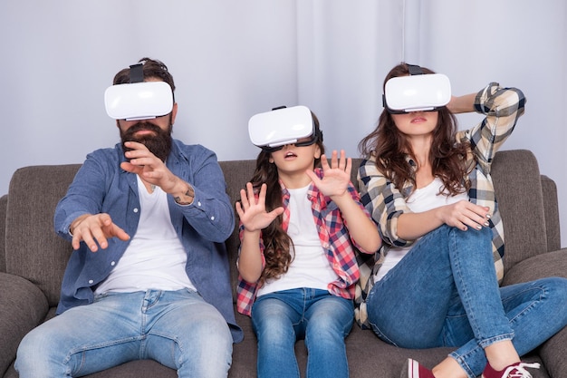 Bange familie draagt een vr-bril die thuis op de bank zit, virtual reality