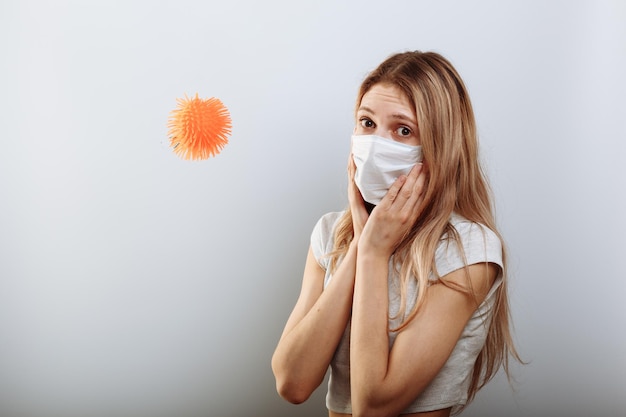 Bange jonge vrouw met medisch masker die in de buurt van covid19-virusmolecuul staat Concept van coronavirus en Aziatische grieppaniek