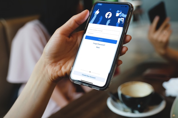 Bangkok. Thailand. 1,2021 maart, logo van Facebook-app voor sociale media op inloggen, aanmeldingsregistratiepagina op scherm van mobiele app op slimme iPhone-apparaten in de hand van zakenman op het werk