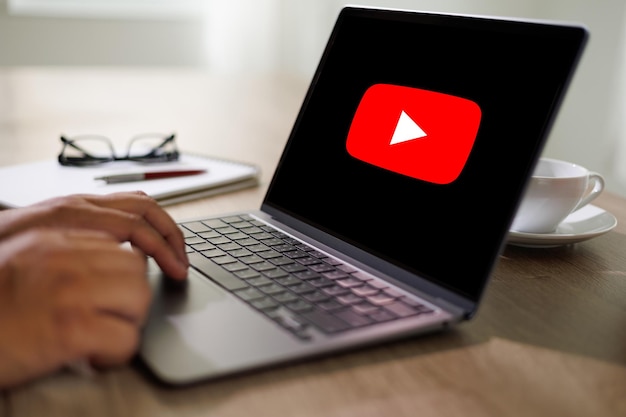 방콕 태국 2022년 4월 25일 화면에 YouTube 로고가 있는 YouTube 웹사이트를 보기 위해 노트북을 사용하는 남자 YouTube는 세계에서 가장 인기 있는 온라인입니다.
