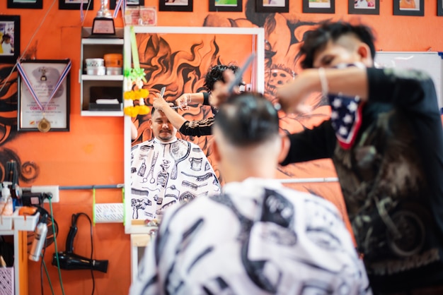 Bangkok, Thailand - April 25, 2017 : Unidentified asian man hairdresser or hairstyle haircut a man plump body customer in fashion hairstyle at barbershop