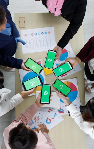 Bangkok/Thailand - August 06, 2021: People hold smartphones in different brands and various operating systems with logos of WhatApp, popular social network messege applications.