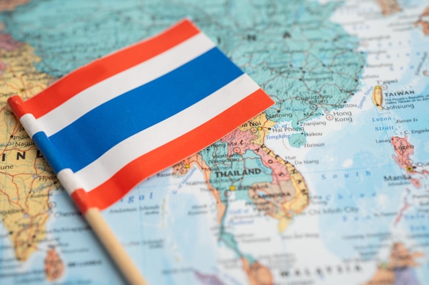 バンコク、タイ-2021年12月7日世界地図の背景にタイの旗。