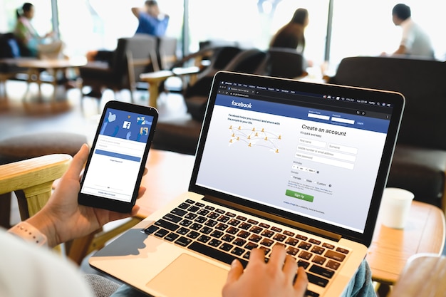 Bangkok. Thailand. JUNE 29,2020 : Woman with MacBook and iPhone with social networking service Twitter on the screen. MacBook and iPhone was created and developed by the Apple inc.