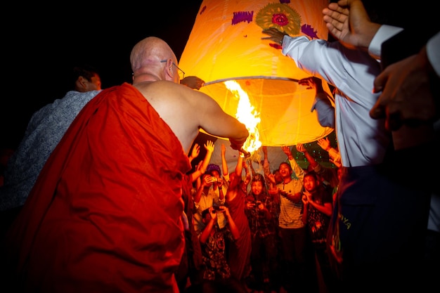 Foto bangladesh 13 oktober 2019 een boeddhistische monnik probeert met zijn discipelen een papieren lantaarn te laten vliegen in de ujani para boeddhistische tempel in bandarban, bangladesh