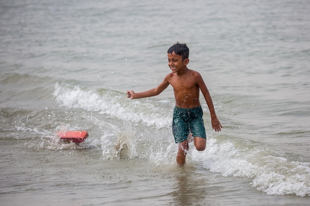 Bangladesh 19 oktober 2018 een vrolijk kind dat speelt op het zeestrandgedeelte van de kustgebieden van de meghna-rivier in chandpur chittagong, bangladesh