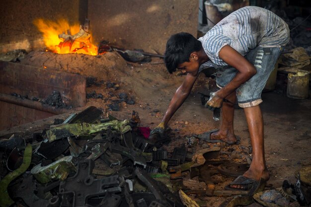 Bangladesh 6 augustus 2019 Een kind werkt zonder enige voorzorg in onveilige, risicovolle en gevaarlijke omstandigheden in Madhabdi Narsingdi, Bangladesh