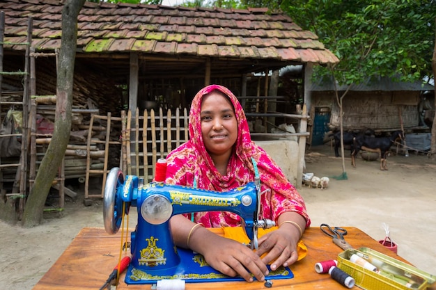 Bangladesh May 19 2019 A middleaged village woman sits in the backyard sewing for her family