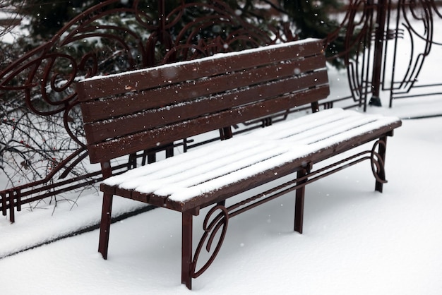 Bank bedekt met sneeuw in stadspark