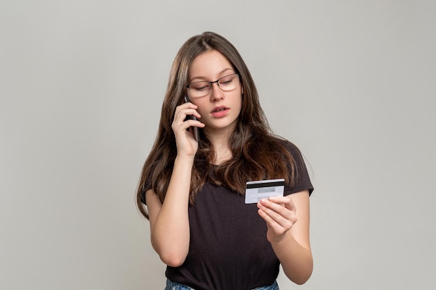 Chiamata bancaria servizio clienti donna problematica che parla con l'operatore al telefono per risolvere il problema della transazione online isolato su grigio verifica della carta di credito istruzioni per il pagamento senza contanti