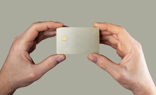 Bank card mockup sample in men hands closeup Blank debit credit bankcard with chip of gold color