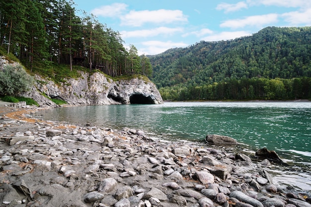 The bank of the Katun river with a natural grotto