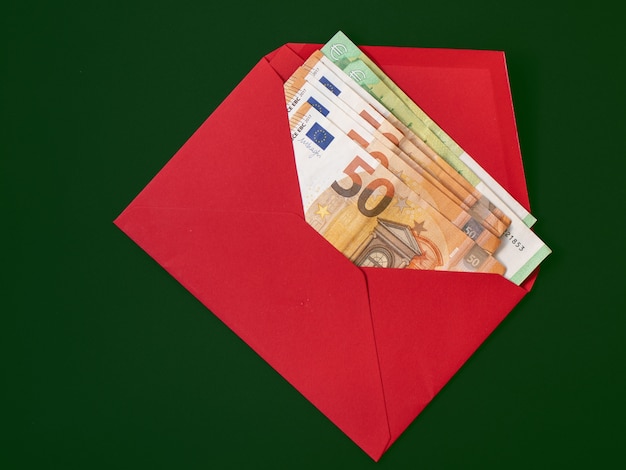 Bank notes in a red envelope on a green background