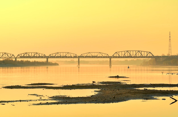 The bank of the Ob River Sandy islands a railway bridge on the horizon in the morning Novosibirsk