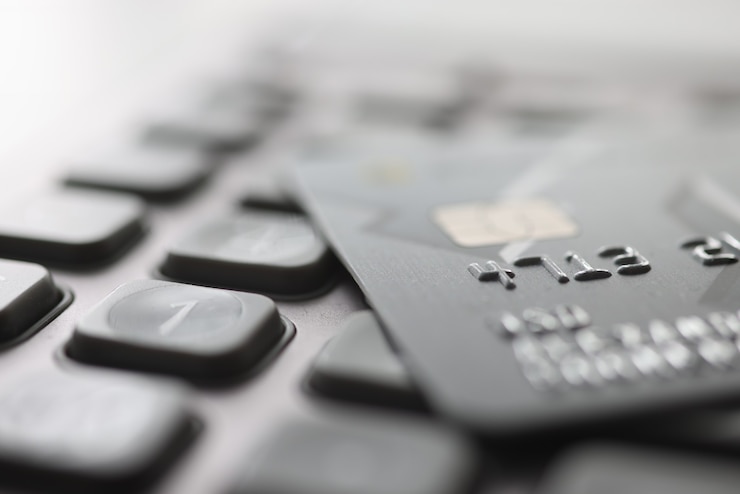 Photo bank plastic card lying on calculator closeup. payment of taxes concept