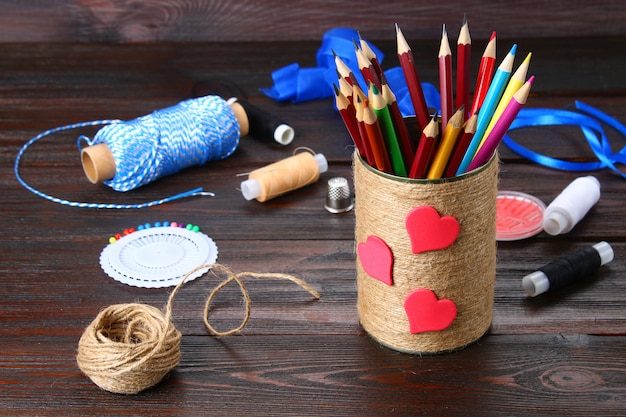 Bank voor potloden met harten omwikkeld met een touwtje op een houten tafel. Handgemaakt.