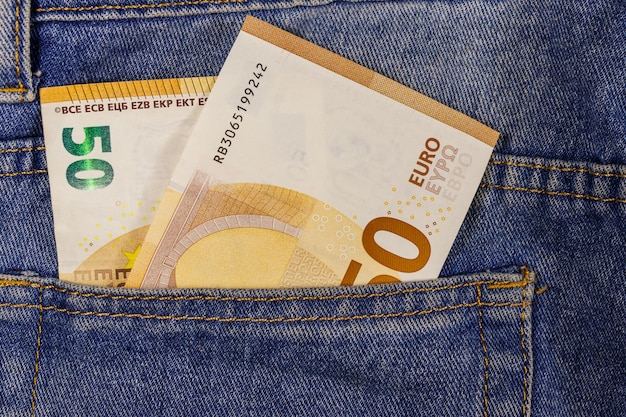 Bankbiljetten van vijftig euro in de zak van een spijkerbroek