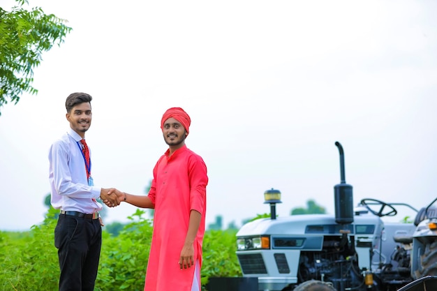 Banker and farmer negotiating bank agriculture loan in field