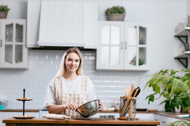 Banketbakker banketbakker jonge blanke vrouw met keukenkom op keukentafel Taarten dessert maken