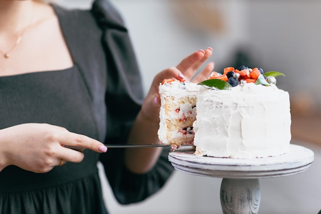 Banketbakker banketbakker jonge blanke vrouw met taart op keukentafel