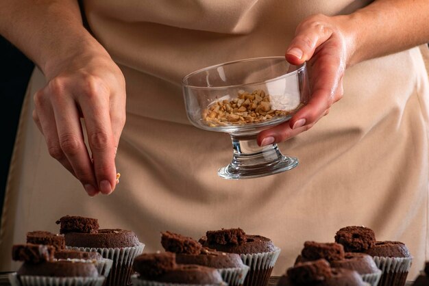 Foto banketbakker bereidt chocolademousxen met notenvulling. proces om cacaomuffins te koken.