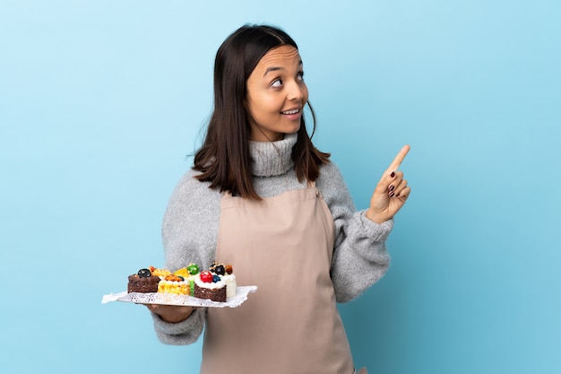 Banketbakker die een plaat met cakes houdt