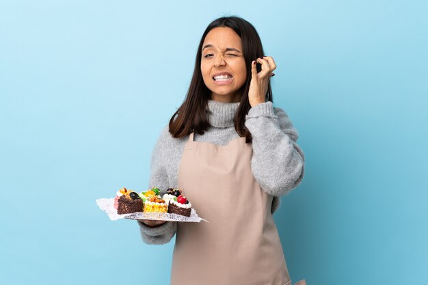 Banketbakker die een plaat met cakes houdt