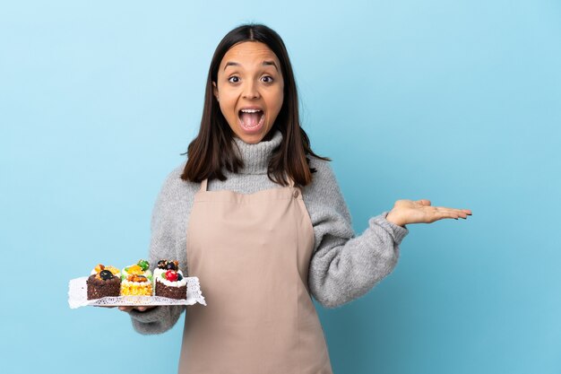 Banketbakker die een plaat met cakes houdt