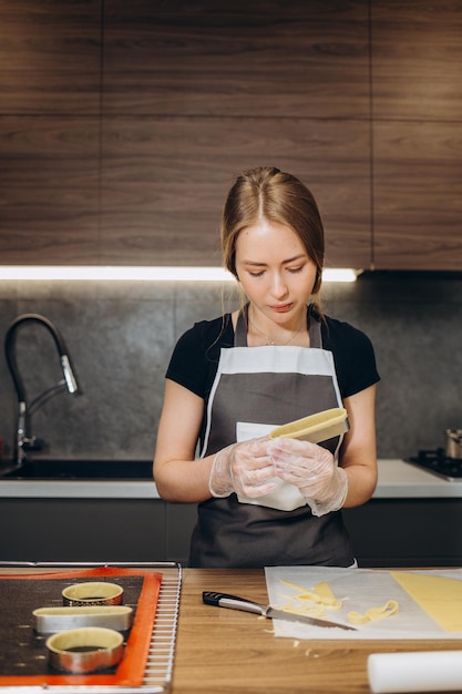 Banketbakker maakt muffins en giet deeg in vormen