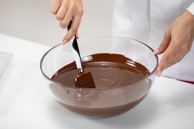 Banketbakker mengt donkere gesmolten Zwitserse chocolade